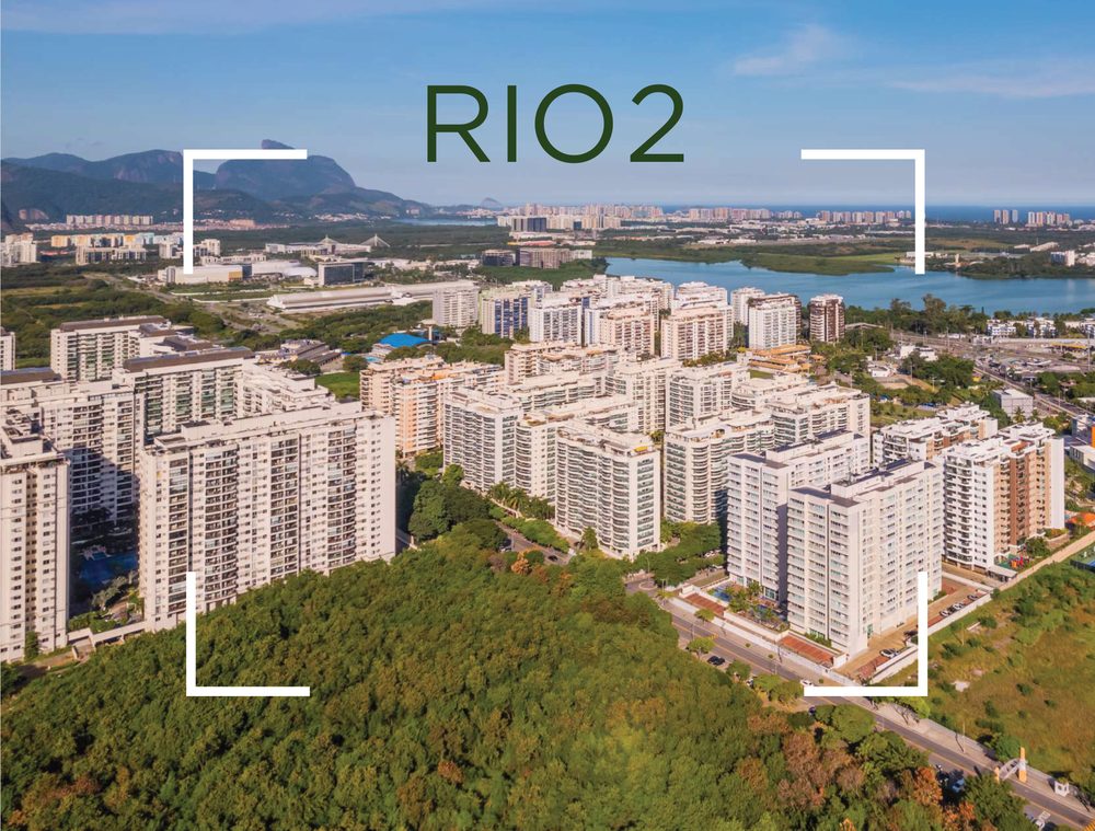 Vista aérea do bairro Rio 2, com os prédios, a lagoa e as montanhas ao fundo
